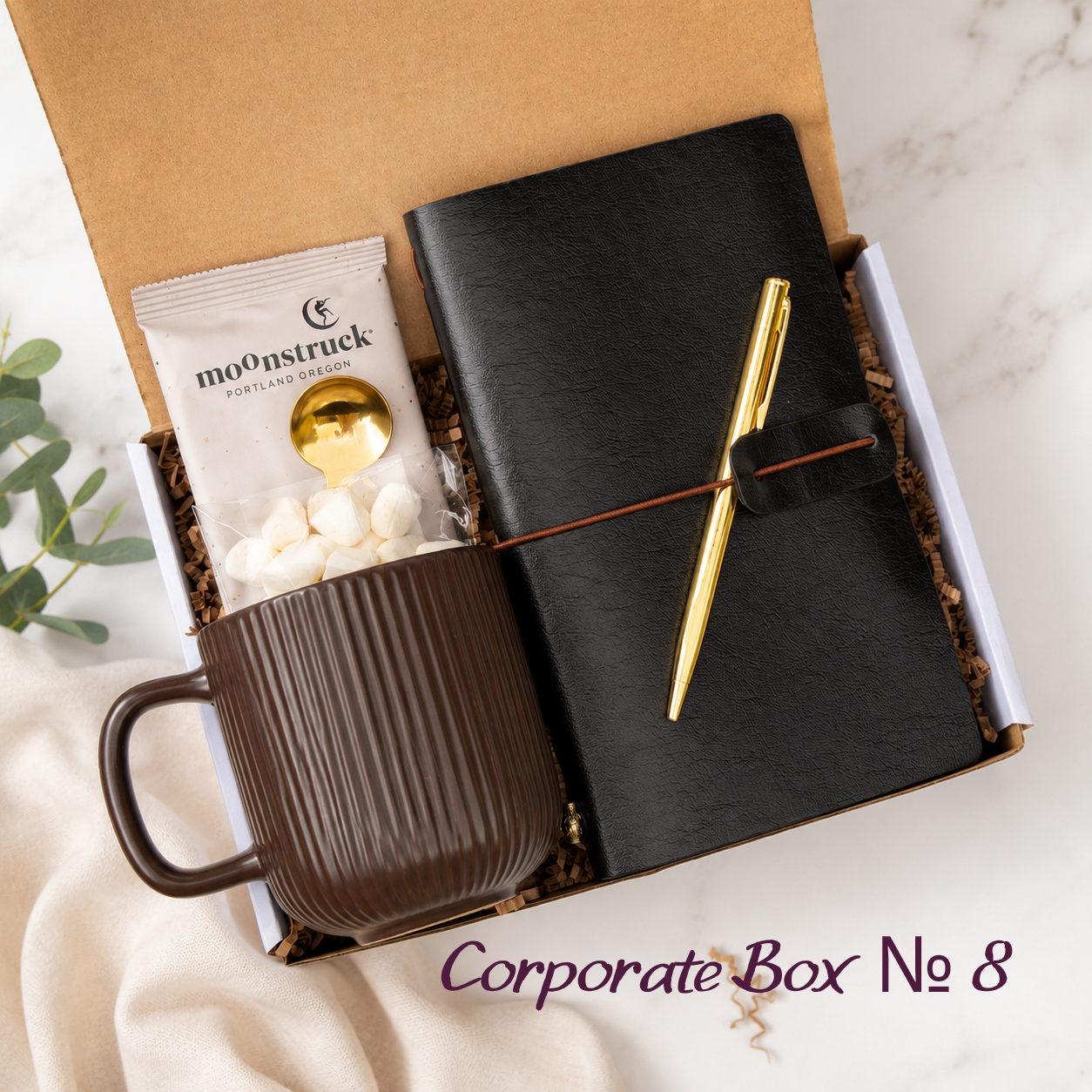 Corporate Gift Box No. 8 with black vegan-leather journal, gold pen, dark brown ribbed mug, Moonstruck white hot cocoa, gold spoon and marshmallows