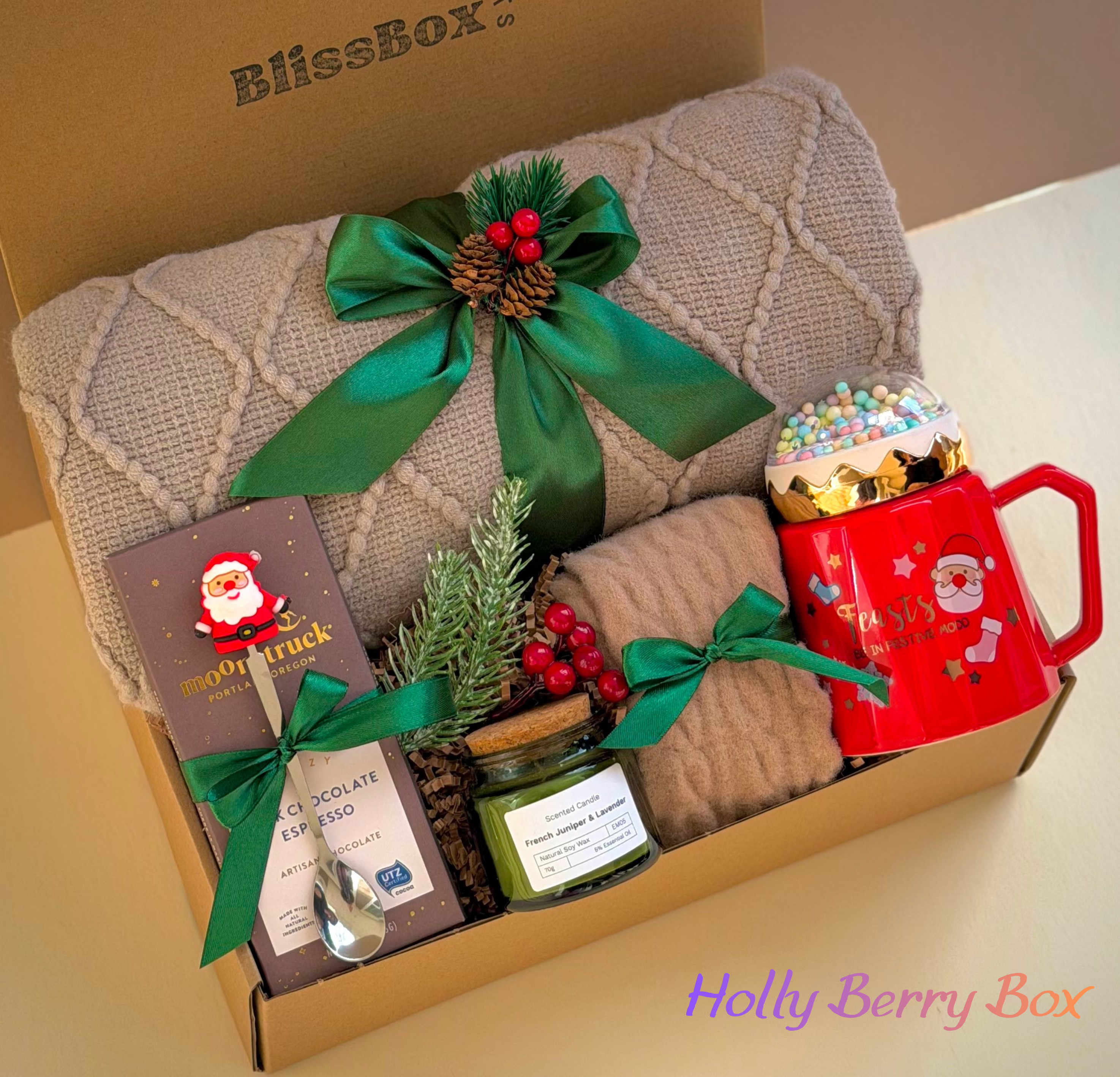holly berry christmas gift box

cozy holiday gift set with blanket mug candle

premium christmas care package for women

festive winter gift box presentation